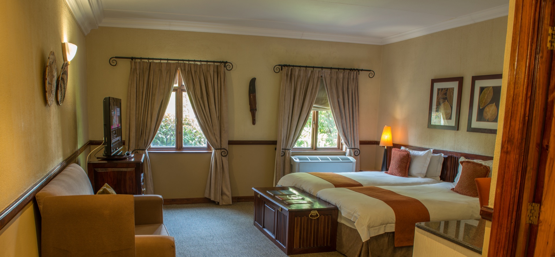 Twin room with armchair and TV at Mondior Gaborone