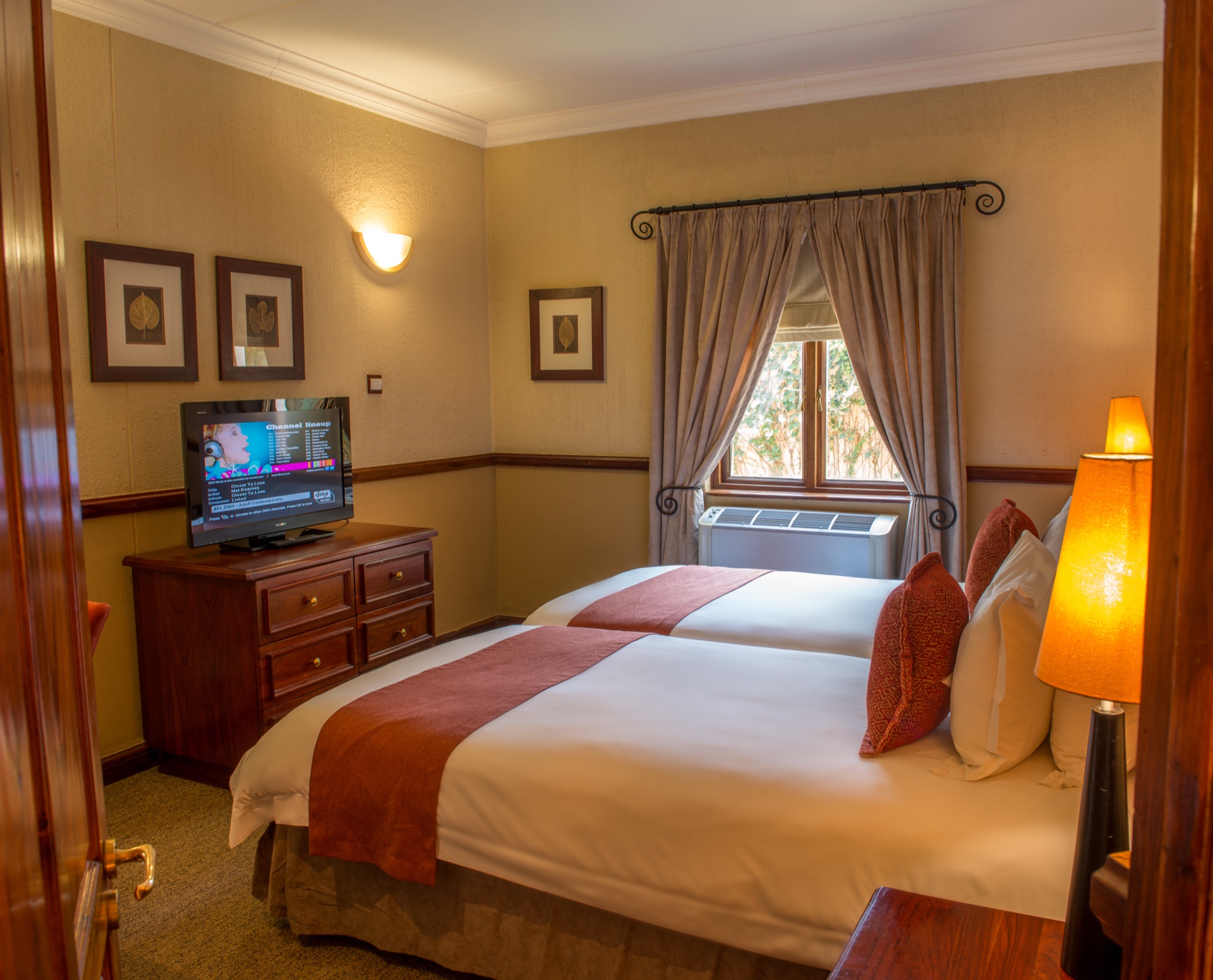 Executive Suite twin beds with framed leaf prints at Mondior Gaborone